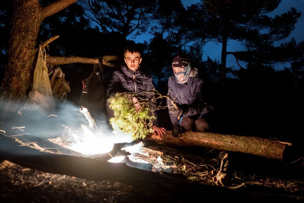 Martin og Jørgen lager fakler av tørre greiner. I den kraftige vinden denne kvelden er ikke det en like populær geskjeft hos kurslederne.
 Foto: Eivind Senneset