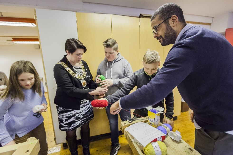Christian Olowo og ordfører Marte Mjøs Persen viser elever på Li skole hvordan en bruker brikkeveven.
 Foto: Otto von Münchow