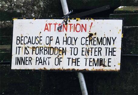 Turisme vs tradisjon: Skiltet advarer turister mot å forstyrre seremoniene som stadig pågår inne i templene.