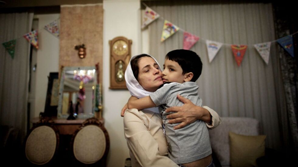 Den iranske dommeren Nasrin Sotoudeh møter igjen sønnen hjemme i Teheran, september 18, 2013, etter å ha sittet tre år i fengsel. Nå er hun dømt til 38 år, og 148 piskeslag.
 Foto:  AFP / Behrouz Mehri