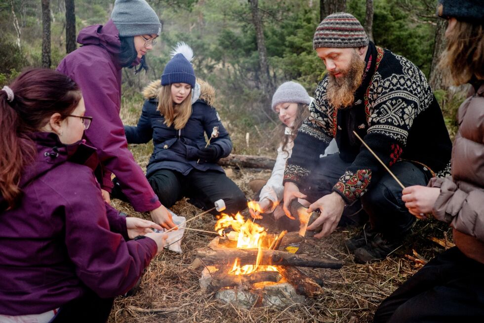 Emilie (fra venstre), Jasmin, Tone, Mathea og Synne griller marshmallows, mens kursleder Hermund Furu hjelper til med bålet.
 Foto: Eivind Senneset