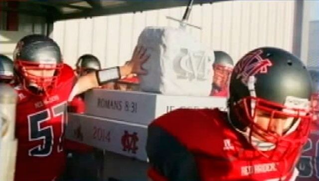 Spillerne på Madison Red Raiders har begynt å ta på monumentet som et ritual før kampen, og det har de tenkt å fortsette med. Berøringen tolkes som en støtte til bibelsitatene. Les mer og se tv-innslag.