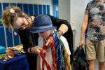 Hvert hus har sitt eget slips. Professor Filomena (Jill Walker Rettberg) hjelper Benjamin (12) med et Taurus-slips. Foto: Eivind Senneset