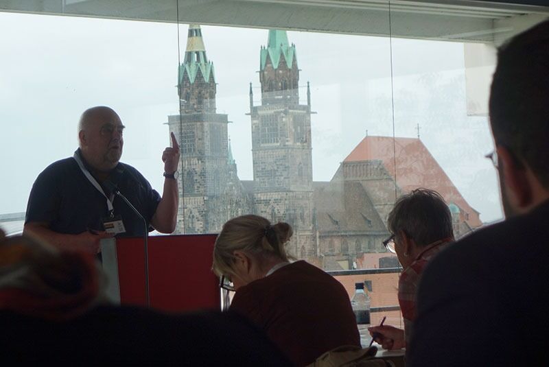 EHFs kasserer Jean De Brueker legger fram regnskapet med Nürnbergs mektige Lorentz-katedral i bakgrunnen.
 Foto: Even Gran