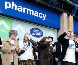 Aksjonister styrter nedpå homøopati-medisin utenfor et Boots-apotek i Leeds, lørdag.