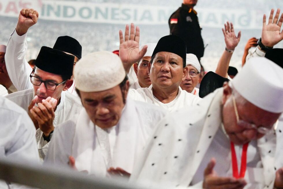 Den indonesiske presidentkandidaten Prabowo Subianto (i midten til høyre, med blikket oppover) i bønn under kampanjemøte på Gelora Bung Karno-stadion i Jakharta 7. april. Onde tunger vil ha det til at han egentlig ikke kan å be.
 Foto: NTB-Scanpix/Abaca
